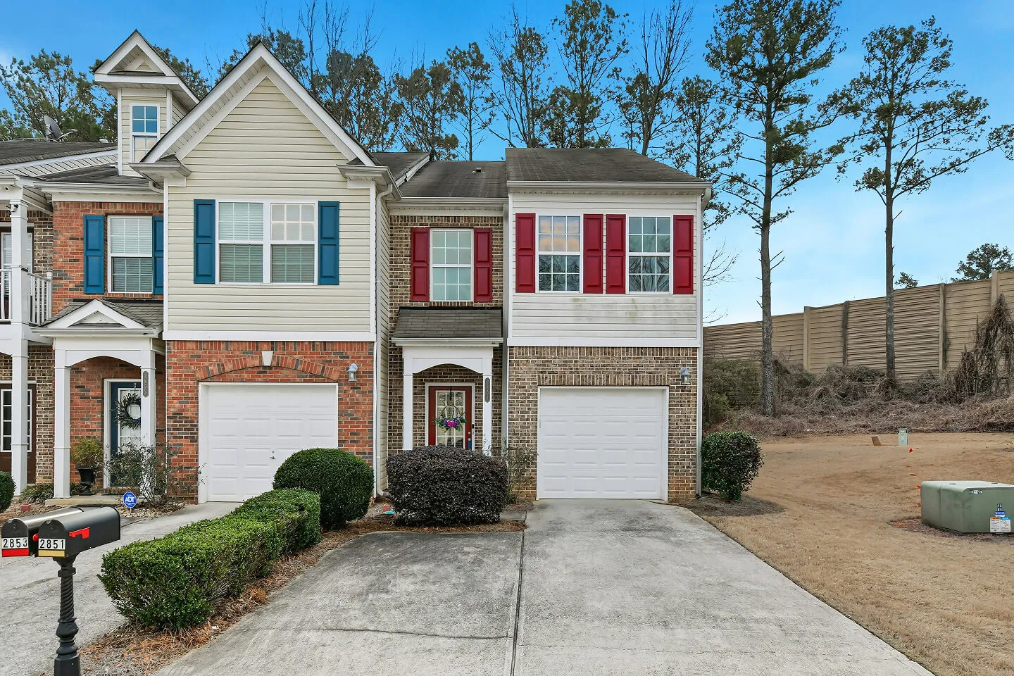 Townhome exterior with brick siding, shutters, and double garage